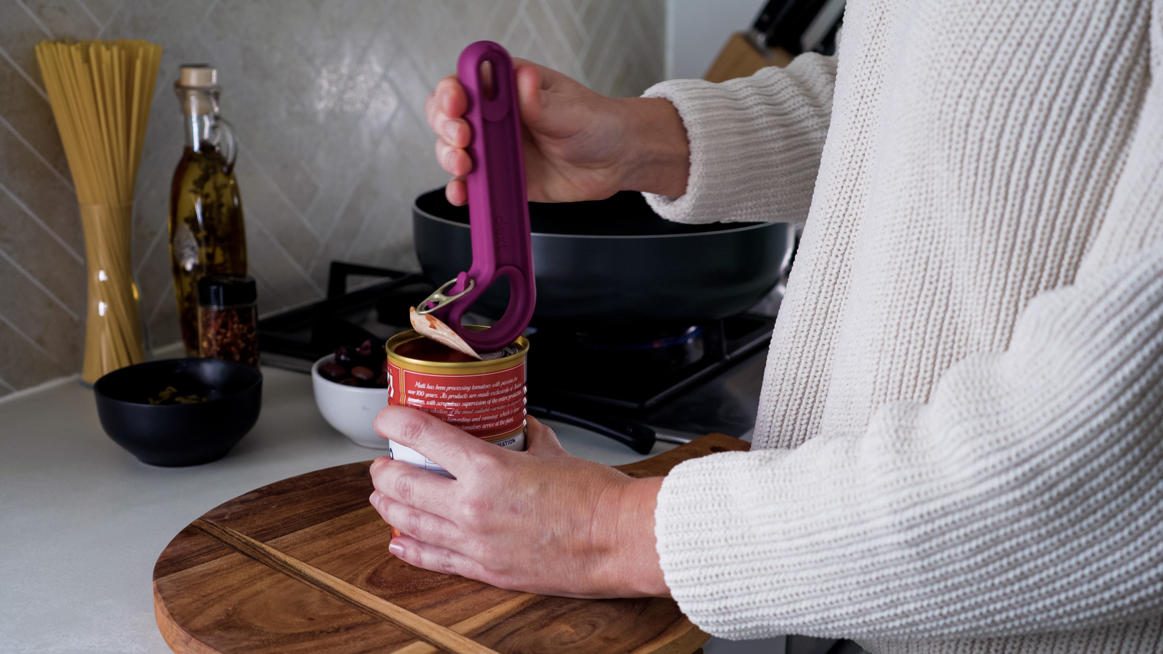 Close up of hands demonstrating the use of the dext ring pull can opener in pink